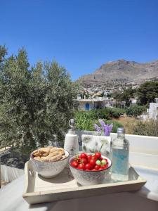 een dienblad met twee kommen groenten en flessen water bij Το σπιτάκι to spitaki Τhe little house in Panormos Kalymnos