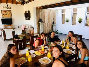 Eine Gruppe von Menschen, die an einem Tisch sitzen und Essen essen. in der Unterkunft Kandyan Mount Mirror Boutique Villa in Kandy