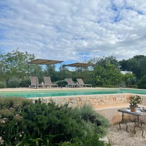 - une piscine avec des chaises longues et des parasols dans l'établissement Casa della Scrittrice, à Ostuni