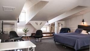 1 dormitorio con 1 cama y sillas en una habitación en Hotel Grodzka 20, en Lublin