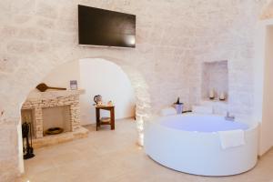 a living room with a white tub and a fireplace at Iconica Luxury Suites in Alberobello