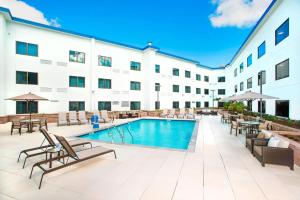 a hotel with a pool and tables and chairs at Courtyard by Marriott Redwood City in Redwood City