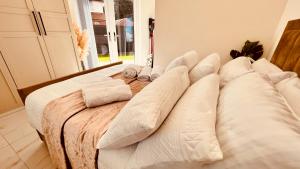 Cozy Charming Bungalow BRAND NEW في بريستون: سرير عليه مخدات في غرفه