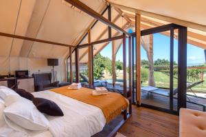 拉宾Floria Glamping Garden的帐篷内的卧室配有大床和阳台