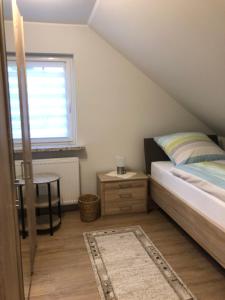 Schlafzimmer mit einem Bett, einem Tisch und einem Fenster in der Unterkunft Ferienhaus Howe in Bergen