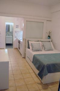 a bedroom with a large bed and a kitchen at Sunset by the sea 2 in Loutraki