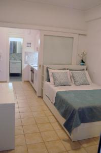 a bedroom with a large bed and a kitchen at Sunset by the sea 2 in Loutraki +13 photos