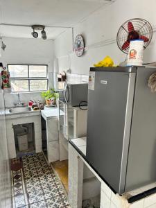 La cuisine est équipée d'un réfrigérateur et d'un évier. dans l'établissement APART PELUSA, à Fray Bentos