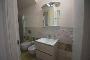 a bathroom with a sink and a toilet and a mirror at Pratza Froria in Villasimius