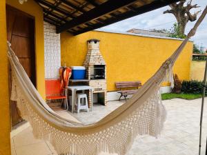 a hammock on the patio of a house at Casa Amarela de Praia in Maricá
