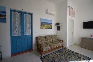 a living room with a couch and a blue door at Pratza Froria in Villasimius