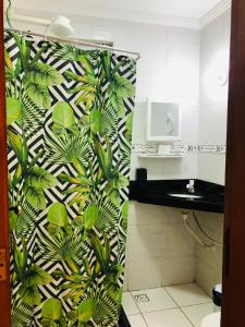 a bathroom with a green and white wallpaper at Casa Amarela de Praia in Maricá