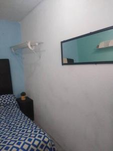 Pokój z łóżkiem i telewizorem na ścianie w obiekcie Recámara comodísima y pequeña w mieście Monterrey