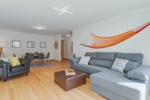 uma sala de estar com um sofá e uma mesa em Sunny Beach Machico Apartment by HR Madeira em Machico