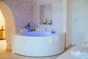 La salle de bains est pourvue d'une baignoire blanche. dans l'établissement Iconica Luxury Suites, à Alberobello