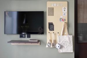 a living room with a flat screen tv and a wall at Bob W Tower Hill Studios in London