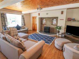 sala de estar con sofá y chimenea en Hillside Lodge en Llandrindod Wells