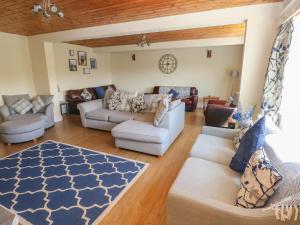 uma sala de estar com sofás e um tapete azul e branco em Hillside Lodge em Llandrindod Wells