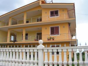 una casa gialla con una recinzione bianca di Guesthouse Fatos Biti a Divjakë