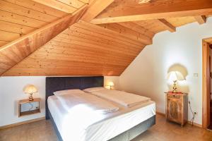 ein Schlafzimmer mit einem großen Bett und Holzdecken in der Unterkunft Annenhof Apt Schwalbenglück in Kaltern