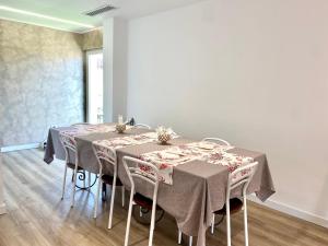 uma sala de jantar com duas mesas com toalha de mesa cinzenta em LD Ianuzziello Residence em Scanzano Jonico
