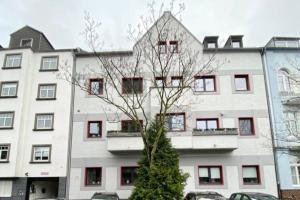 un gran edificio blanco con un árbol delante en Charming home away: close to Dusseldorf Messe, en Düsseldorf