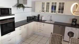 a white kitchen with a sink and a dishwasher at BIG Apartment - 150qm in Bad Liebenwerda in Bad Liebenwerda