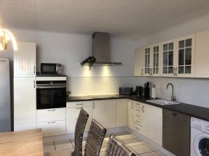 a kitchen with white cabinets and a table and chairs at BIG Apartment - 150qm in Bad Liebenwerda in Bad Liebenwerda