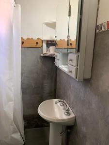 y baño con lavabo y espejo. en Cabaña Los Girasoles Cachi Salta en Cachí