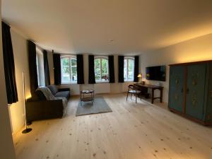 sala de estar con sofá, mesa y ventanas en Gasthof Zantl en Bad Tölz