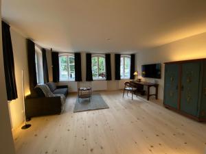 a living room with a couch and a table and windows at Gasthof Zantl in Bad Tölz