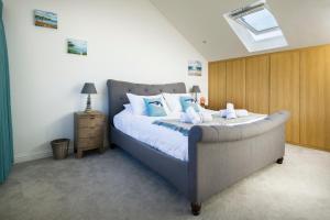 ein Schlafzimmer mit einem großen Bett mit blauen Kissen in der Unterkunft Cedar Lodge in Carbis Bay