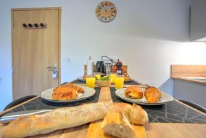 una mesa con platos de pan y bollería. en Le Sabot - Netflix/Wi-Fi Fibre/Terasse - 4 pers en Banassac