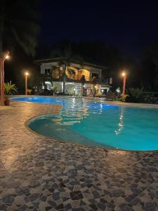 - une piscine avec une maison la nuit dans l'établissement Bregman Residence, 
