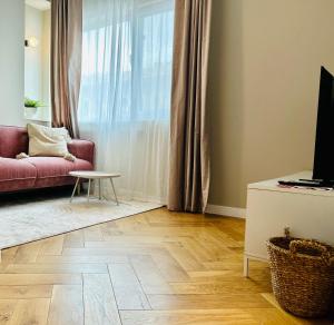 a living room with a red couch and a table at Ultracentral Lux Boutique 1BR Ap Near Subway in Bucharest