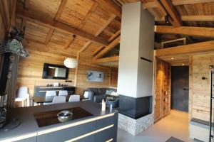 a kitchen and living room with wooden walls and ceilings at Chalet Niyama in Font-Romeu-Odeillo-Via
