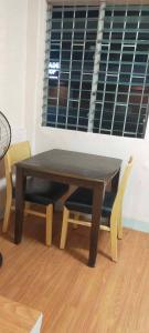 einen Holztisch und Stühle in einem Zimmer mit Fenster in der Unterkunft Perfect for Couples Room in Cebu City