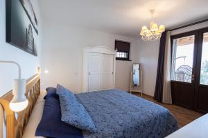 Un dormitorio con una cama azul y un sofá. en Di Colle In Colle - Country House with Private Pool, en Tuoro sul Trasimeno