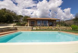 une villa avec une piscine en face d'une maison dans l'établissement Di Colle In Colle - Country House with Private Pool, à Tuoro sul Trasimeno