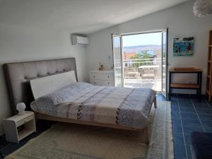 um quarto com uma cama e uma porta de vidro deslizante em Rosemary Resort em Cesarica
