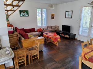 una sala de estar con un sofá y una mesa en Villa Marena Adaptee handicapes, en Dolus d'Oléron