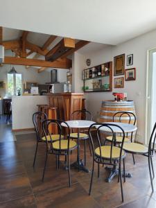 Una habitación con mesas y sillas y una cocina. en Villa Marena Adaptee handicapes, en Dolus d'Oléron