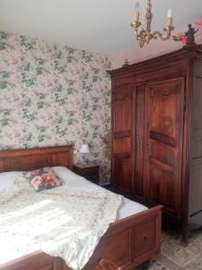 a bedroom with a bed and a dresser with flowers at Rosalie Cottage in Beaurepaire
