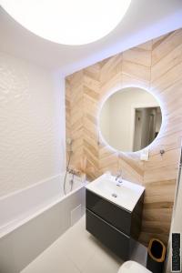 W łazience znajduje się biała umywalka i lustro. w obiekcie Apartament 12 w mieście Chojnice