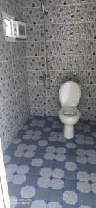 a bathroom with a toilet in a tiled room at The Endless Enigma in Tazroutane