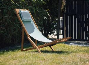 a chair sitting in the grass in a yard at La Chomotte in Saint-Alban-dʼAy