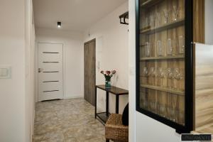 a hallway with a wine cellar with glasses on the shelves at Apartament 12 in Chojnice
