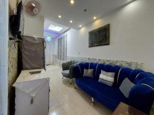 a living room with a blue couch and a table at شقق فندقيه فاخره in Kafr Abū ʼumaydah