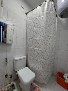 a bathroom with a toilet and a shower curtain at شقق فندقيه فاخره in Kafr Abū ʼumaydah