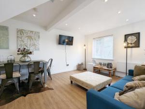 ein Wohnzimmer mit einem Tisch und einem blauen Sofa in der Unterkunft The Gofflet, Petworth in North Chapel